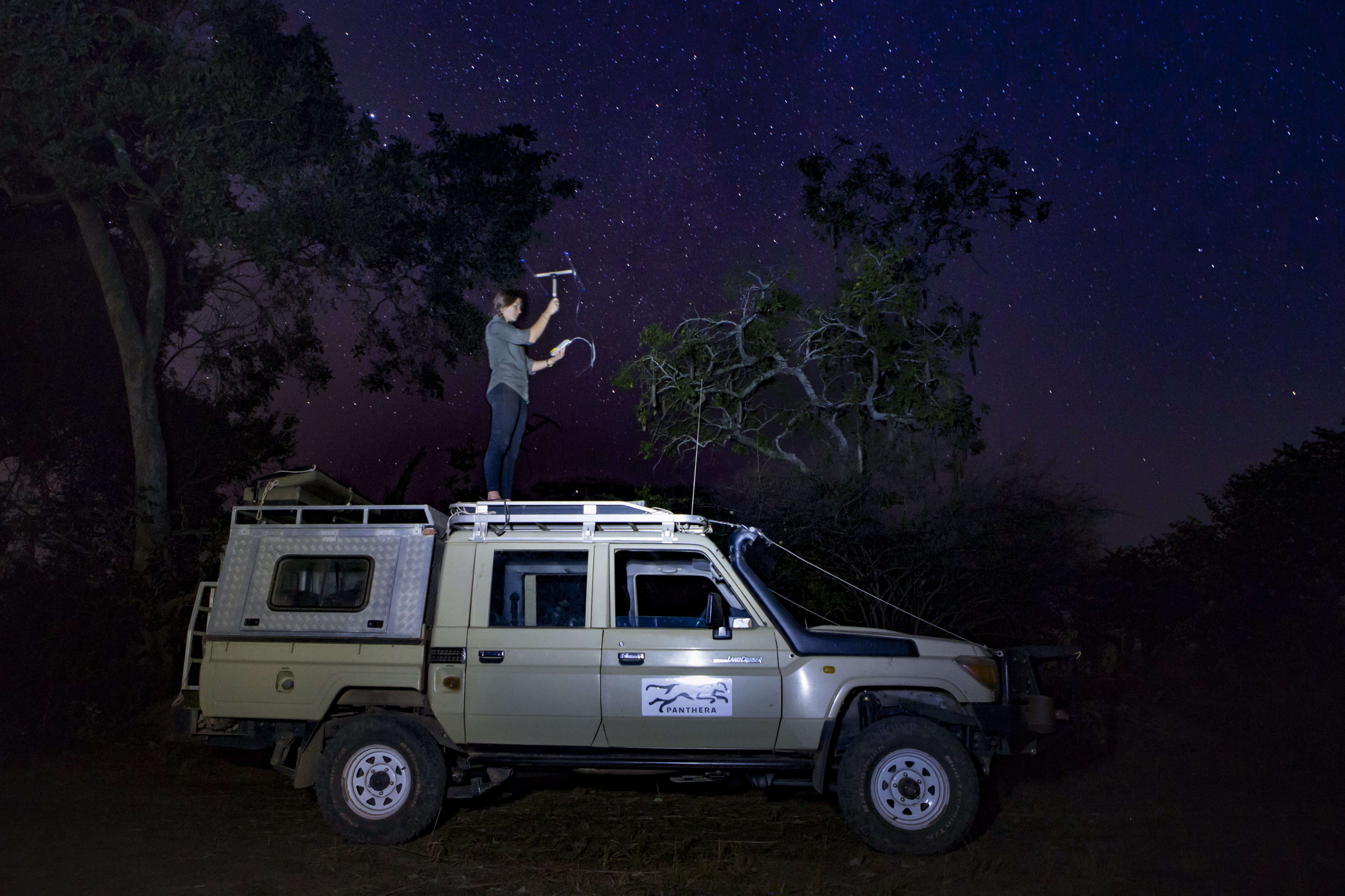 "African Lion biologist, Xia Stevens, tracking female lion at night, Kafue National Park, Zambia"