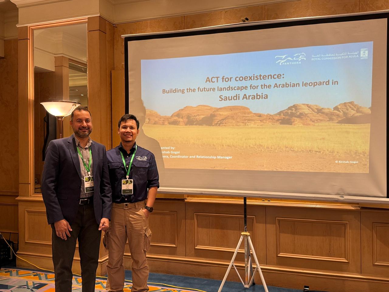 Two presenters stand in front of a screen.&nbsp;&nbsp;