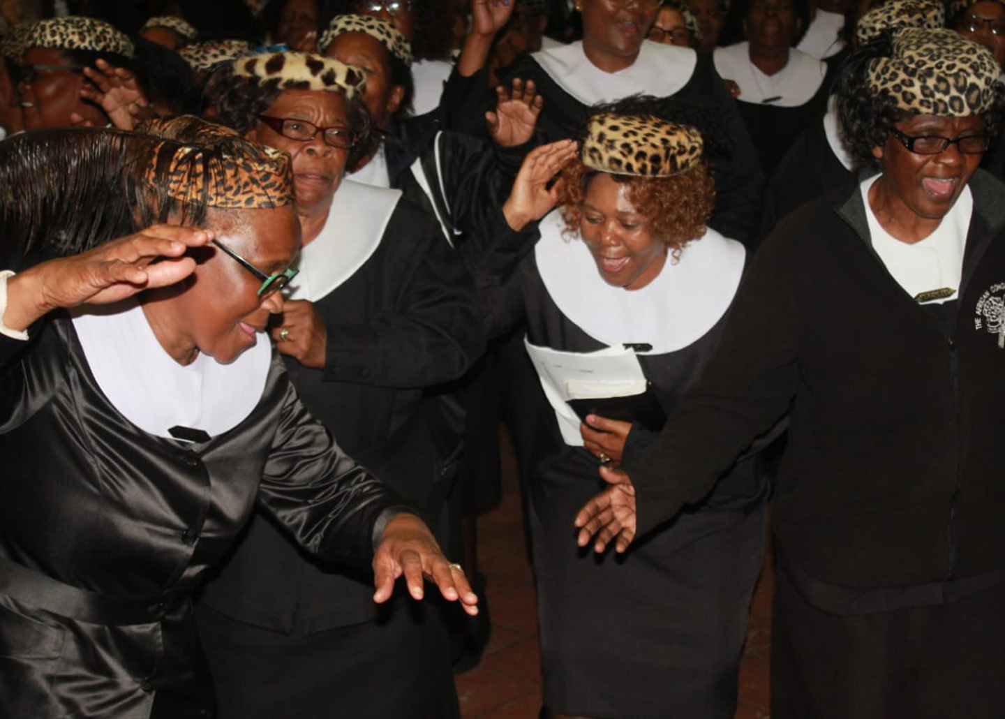 Women wearing fake leopard hats singing and dancing