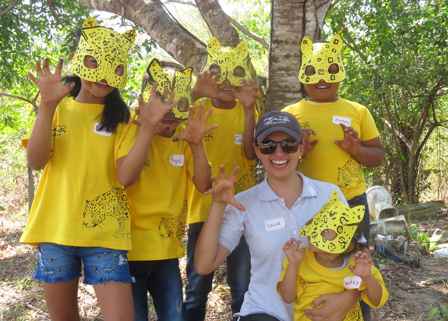 Children in jaguar masks with teacher