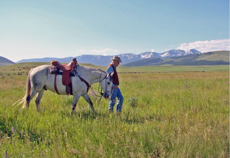 Ted Turner with his horse on his Montana ranch