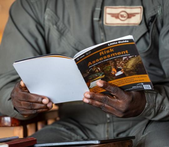 Person holding a printed Little Guide