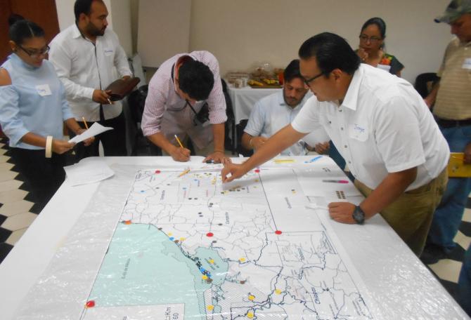 Members of the Panthera Mexico team working around a map