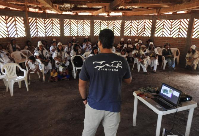 Man giving presentation regarding Colombia Program to the natives